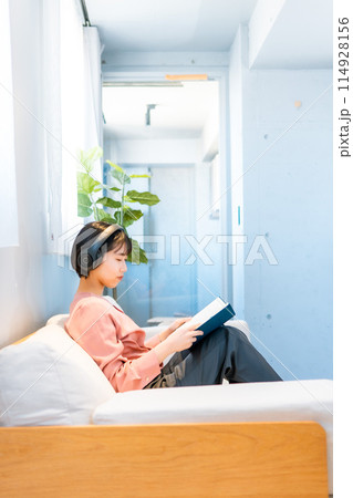 音楽を聴きながら読書をする女性/リスキリング 114928156