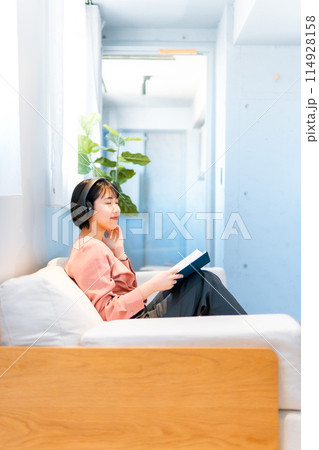 音楽を聴きながら読書をする女性/リスキリング 114928158
