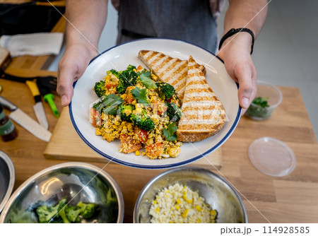 Chef at the kitchen preparing tofu scramble with vegetables 114928585