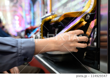 パチンコ台で遊戯する男性 114929347