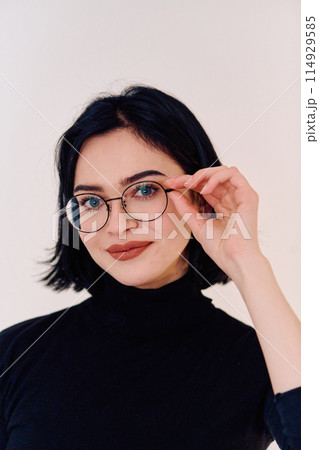 Smiling Brunette Woman Wearing Eyeglasses Poses on White Background 114929585