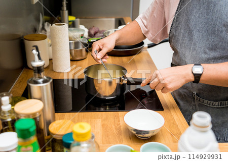 Chef at the kitchen preparing green curry with herbs and rice 114929931