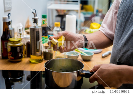 Chef at the kitchen preparing green curry with herbs and rice Chef at the kitchen preparing green curry with herbs and rice 114929961