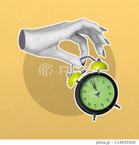 Hand setting time on a vintage alarm clock 114930308