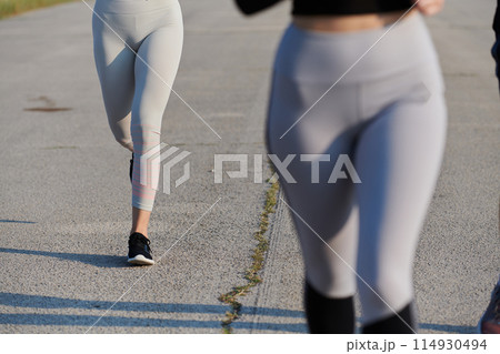 Close-Up: Athletic Runner's Legs Captured in Action on a Sunny Day. Close-Up: Athletic Runner's Legs Captured in Action on a Sunny Day. 114930494