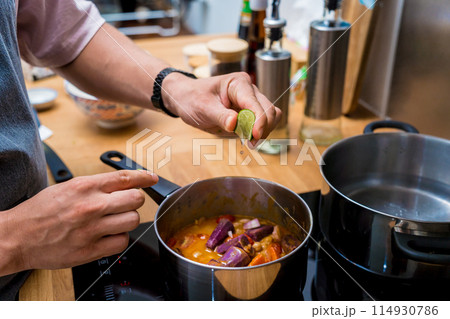 Chef at the kitchen preparing massaman curry with sweet potato and many spices Chef at the kitchen preparing massaman curry with sweet potato and many spices 114930786