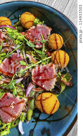 Salad with tuna and cheese balls topped with soy sauce. Fast and healthy food. 114933503