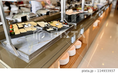 A buffet table with a variety of dishes, including fast food, various cheeses and savory snacks A buffet table with a variety of dishes, including fast food, various cheeses and savory snacks 114933937