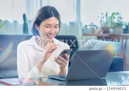 部屋でパソコンを操作する若い女性 114934013