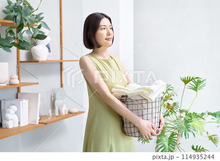 洗濯かごを抱えた若い女性 114935244