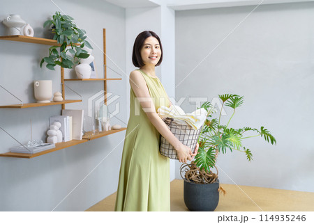 洗濯かごを抱えた若い女性 114935246