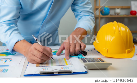Architect or engineer sitting at desk in office, Cost calculation, Construction planning, structural calculation, Project construction cost planning and calculation, Project presentation plan. Architect or engineer sitting at desk in office, Cost calculation, Construction planning, structural calculation, Project construction cost planning and calculation, Project presentation plan. 114936642