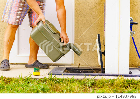 Man emptying caravan tank toilet cassette in dump station. 114937968