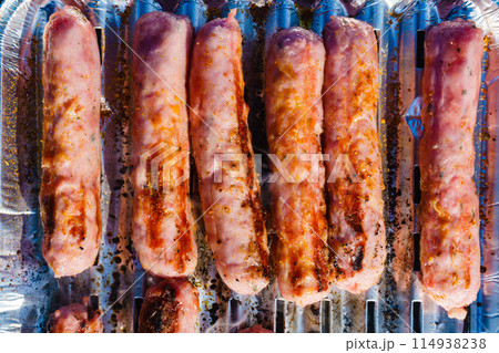 Sausages meat grilling on gas grill 114938238