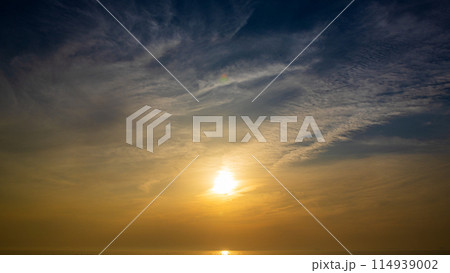 夕暮れの空に沈む夕陽と流れゆく雲 夕暮れの空に沈む夕陽と流れゆく雲 114939002