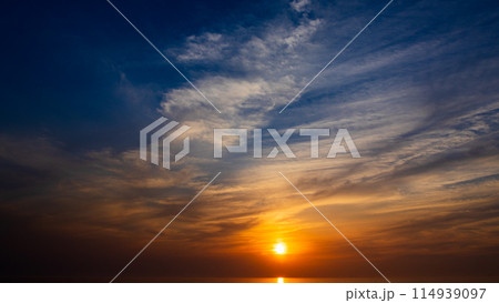 夕暮れの空に沈む夕陽と流れゆく雲 夕暮れの空に沈む夕陽と流れゆく雲 114939097