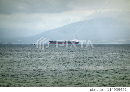 Sea freighter sailing in the middle of the ocean with big waves. Sea freighter sailing in the middle of the ocean with big waves. 114939421