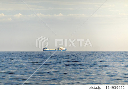 Sea freighter sailing in the middle of the ocean with big waves. Sea freighter sailing in the middle of the ocean with big waves. 114939422