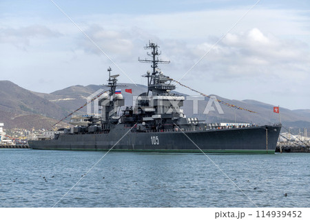 Novorossiysk, Russia - 18 August 2023. Cruiser Mikhail Kutuzov and dolphins, Black Sea, port, Krasnodar Territory, Novorossiysk. Novorossiysk, Russia - 18 August 2023. Cruiser Mikhail Kutuzov and dolphins, Black Sea, port, Krasnodar Territory, Novorossiysk. 114939452