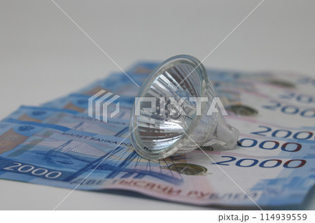 White electric cable and banknotes, expensive electricity, saving electricity. White electric cable and banknotes, expensive electricity, saving electricity. 114939559