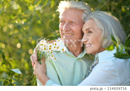 Portrait of beautiful senior couple by lilacs in the park Portrait of beautiful senior couple by lilacs in the park 114939716
