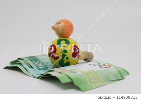 Bird nest with banknotes and a wooden bird whistle. Family budget. Bird nest with banknotes and a wooden bird whistle. Family budget. 114939815