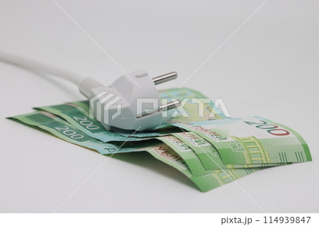 White electric cable and banknotes, expensive electricity, saving electricity. 114939847