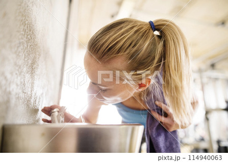 Beautiful sport woman drinking water afeter training in gym. Routine workout for woman's physical and mental health. Beautiful sport woman drinking water afeter training in gym. Routine workout for woman's physical and mental health. 114940063