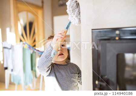Little boy helping mother with hosehold chores, dusting cleaning their house. Weekly chores, weekend activities. 114940186