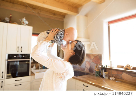 Mother holding small baby, carrying him around house. Unconditional paternal love, mother's Day concept. 114940227