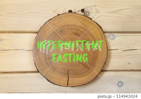 Intermittent fasting symbol. Concept words Intermittent fasting on beautiful wooden circle. Beautiful wooden wall background. Healthy lifestyle intermittent fasting concept. Copy space. Intermittent fasting symbol. Concept words Intermittent fasting on beautiful wooden circle. Beautiful wooden wall background. Healthy lifestyle intermittent fasting concept. Copy space. 114941024