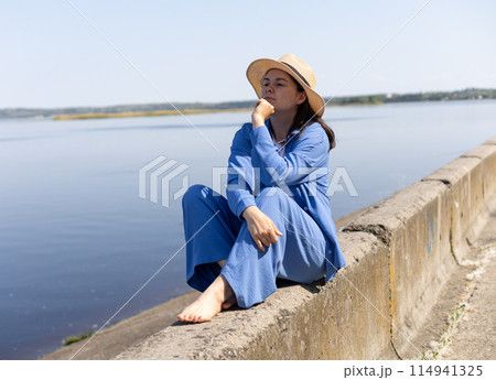 thoughtful young woman sits on the seashore thoughtful young woman sits on the seashore 114941325