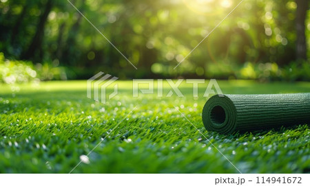 Green yoga mat lies on vibrant lawn, ready for healing session amidst natures embrace, copy space 114941672