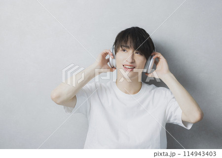 音楽を聴く若い男性　 114943403