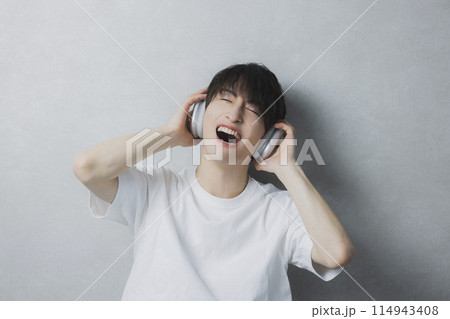 音楽を聴く若い男性　 114943408
