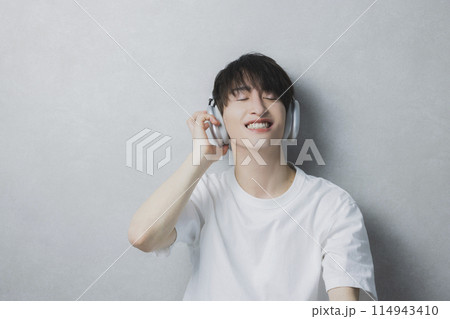 音楽を聴く若い男性　 114943410
