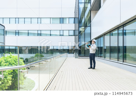 タブレットを使ってビルを点検するエンジニア 114945673