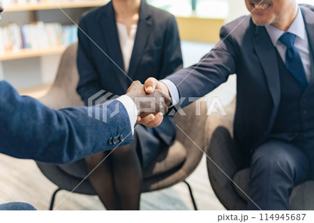 ラウンジで握手する多国籍ビジネスパーソンのグループ 114945687