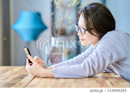 疲れた様子でスマートフォンを操作する女性 114946265