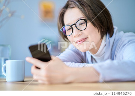 疲れた様子でスマートフォンを操作する女性 114946270