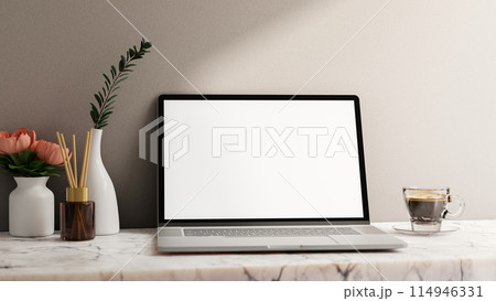 A laptop computer white-screen mockup on a white marble table against the white wall. A laptop computer white-screen mockup on a white marble table against the white wall. 114946331
