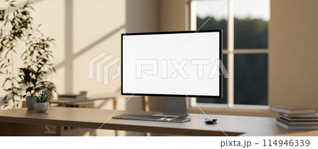 A computer with a white-screen mockup on a wooden table in a modern, minimalist home office. A computer with a white-screen mockup on a wooden table in a modern, minimalist home office. 114946339