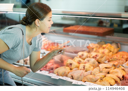 Girl customer points with finger and orders whole chicken fresh poultry 114946408