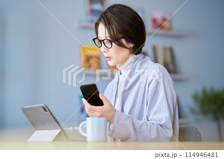 タブレットPCとスマートフォンを操作する女性 114946481