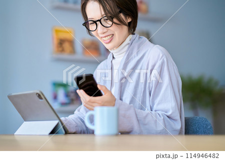 タブレットPCとスマートフォンを操作する女性 114946482