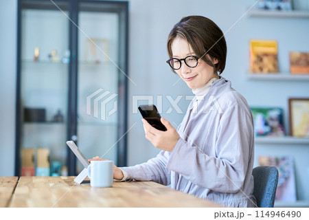 タブレットPCとスマートフォンを操作する女性 114946490