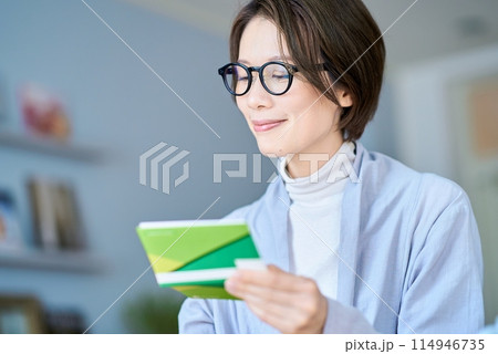 銀行口座の通帳を見る女性 114946735