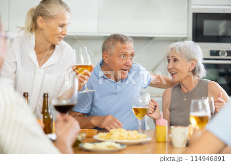 Happy seniors chatting at dinner table. Concept of happy life together in nursing home Happy seniors chatting at dinner table. Concept of happy life together in nursing home 114946891