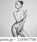 Sexy naked girl with a beautiful body posing in a photo studio. 114947796
