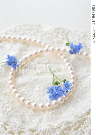 真珠のネックレスと白いレースと青い花 114947908